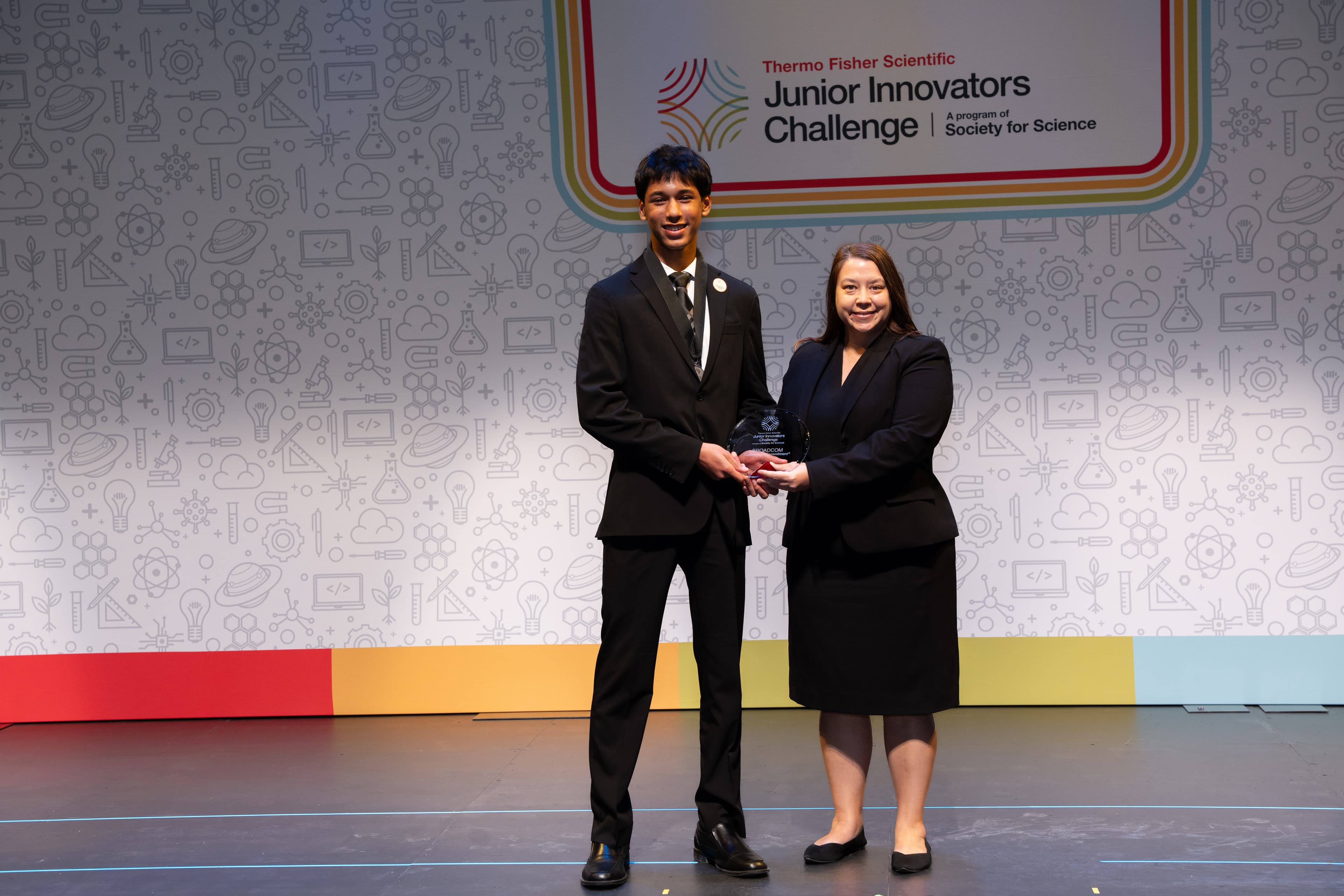 Akhil Nagori holding the Broadcom award on stage at the Junior Innovators Challenge
